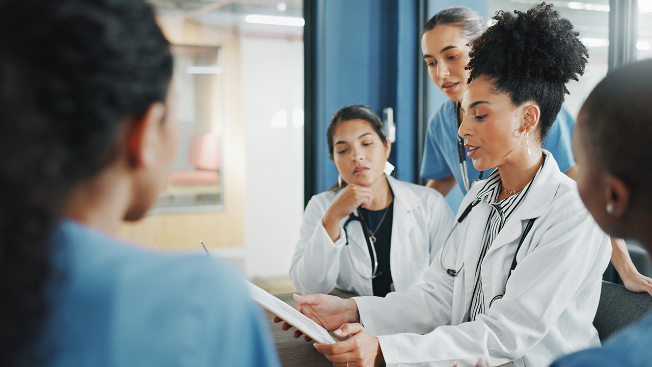 Doctors and nurses gathering around for a meeting in the hospital